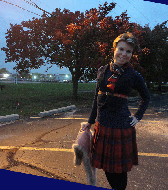 It gets dark now. Sorry. Red plaid skirt, navy shirt, navy vest, and scarf and belt with red detailing. 