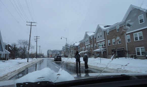Some kids walking through the snow. 